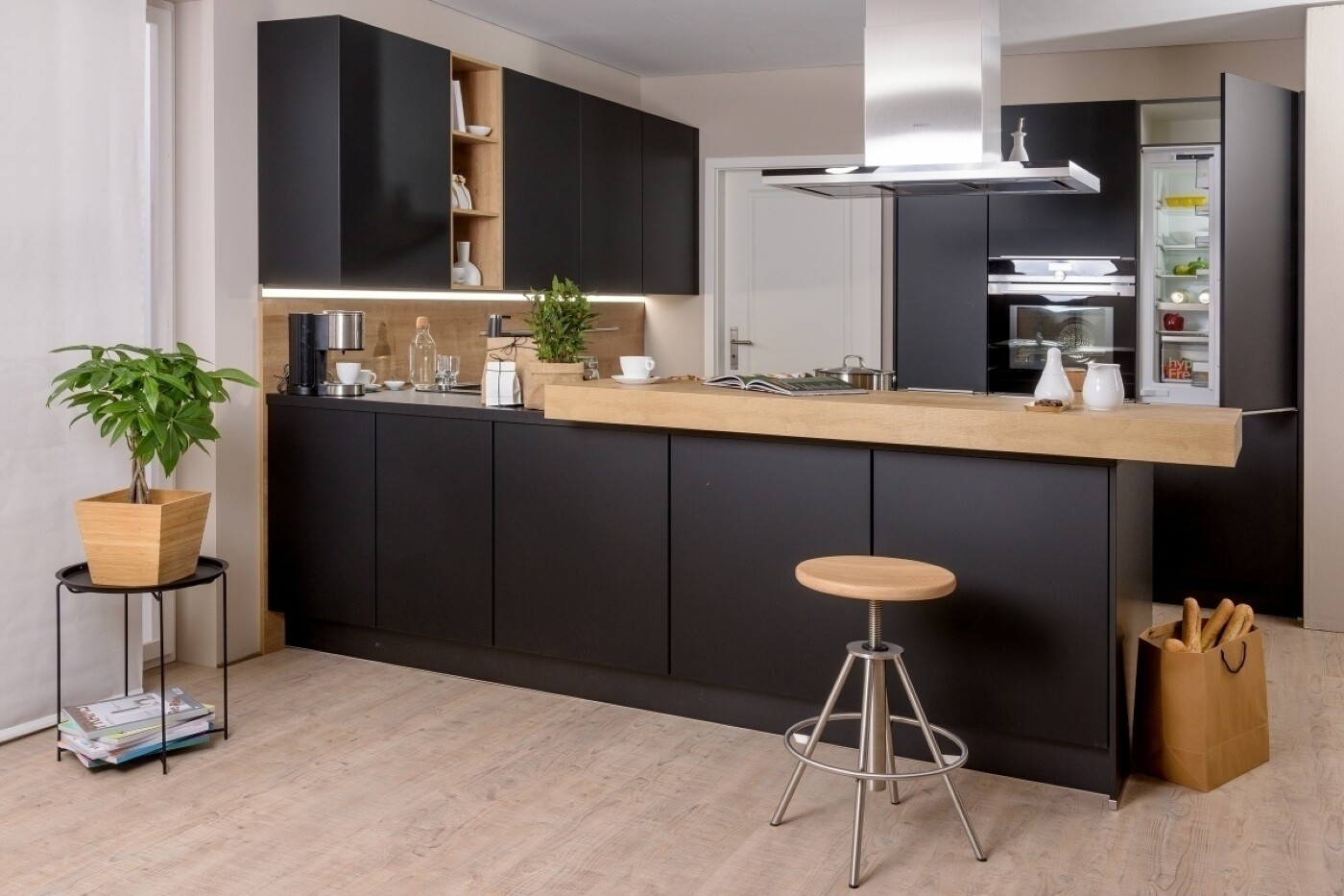 Schwarzes Küchendesign mit freistehender Küchentheke, die auch als Esstheke fungiert Schwarzes Küchendesign mit freistehender Küchentheke, die auch als Esstheke fungiert