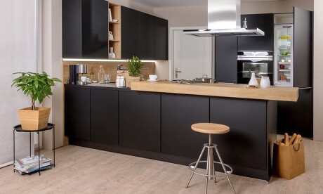 Schwarzes Küchendesign mit freistehender Küchentheke, die auch als Esstheke fungiert Schwarzes Küchendesign mit freistehender Küchentheke, die auch als Esstheke fungiert