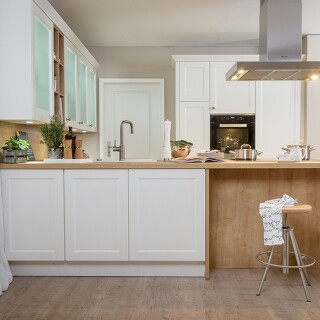 Freistehende Küchentheke, die rückseitig mit Unterschränken und einem Barbereich ausgestattet ist Freistehende Küchentheke, die rückseitig mit Unterschränken und einem Barbereich ausgestattet ist